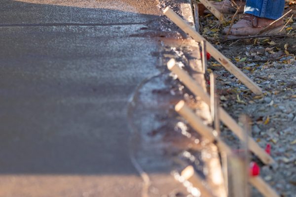 Construction Worker Smoothing Wet Cement With Trowel Tools