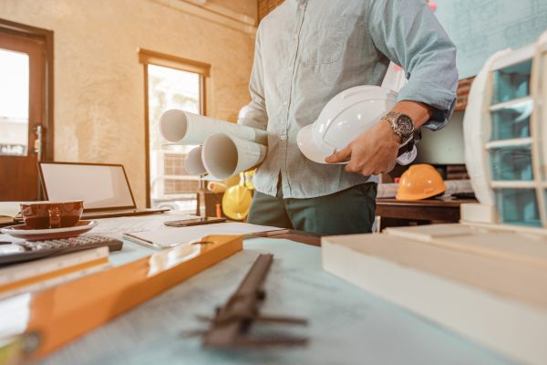 Male architect are holding on blueprint and helmet working engineering or architecture project to come out completely. Engineer, Engineering, Architecture, Blueprint, Planning, Occupation concept.